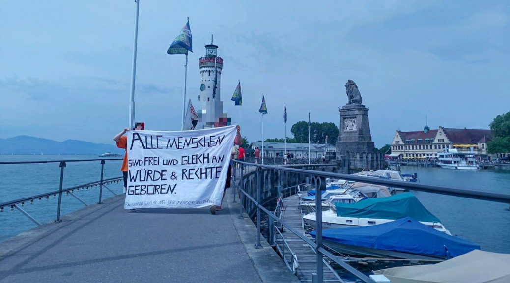 Etwa 50 Personen demonstrieren am Lindauer Hafen im Rahmen des Seebrücke-Aktionstages für sichere Häfen.