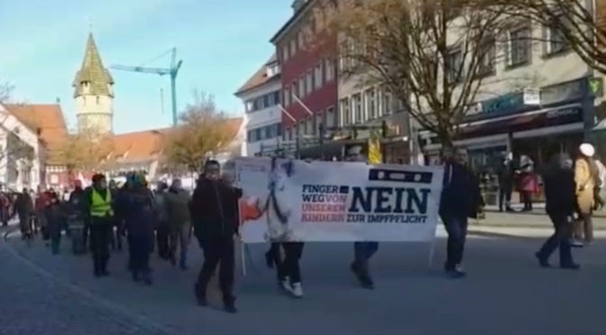 Vermeintliche »Spaziergänger« trage im ersten Drittel des Querdenken-Aufzugs am 12. Februar 2022 in Ravensburg ein Banner des Deutsche-Stimme-Verlags der NPD - und versuchen das zu verschleiern.